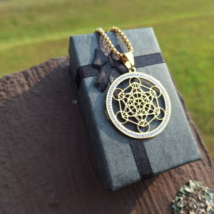 Gold-tone Metatron's Cube pendant necklace with clear quartz accents on gift box