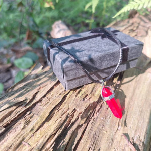Vivid red quartz crystal point necklace displayed beside gift box