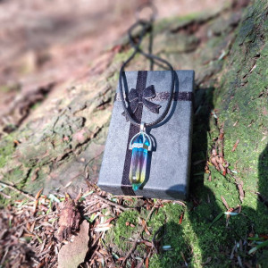 Rainbow-tone quartz crystal point necklace displayed on gift box